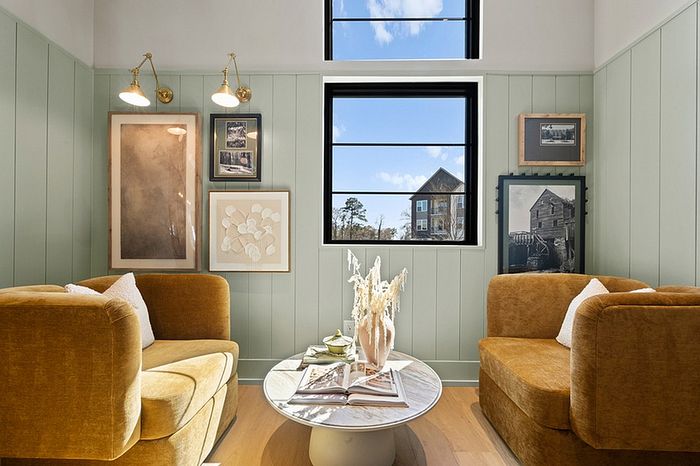 Charming sitting area with plush mustard armchairs, contemporary wall art, and a bright window view, creating an inviting and cozy atmosphere.