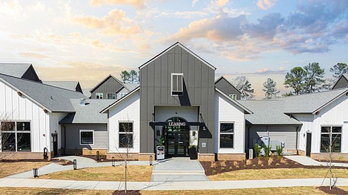 Charming leasing office with modern architectural design set against a picturesque sky, welcoming visitors with its inviting ambiance.