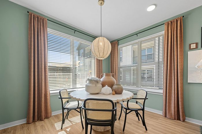 Charming dining nook with large windows, stylish lighting, and elegant decor, perfect for a cozy meal.