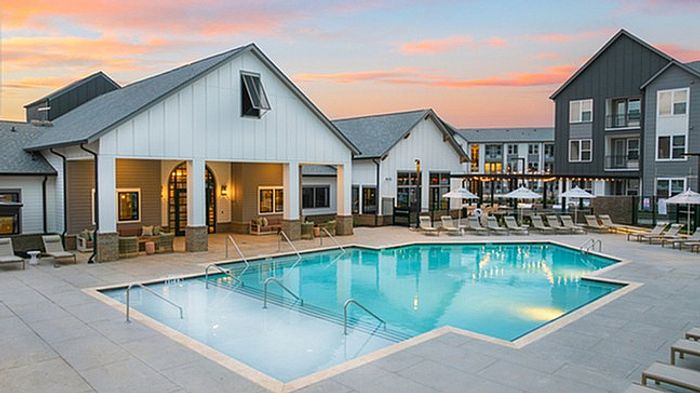 Charming apartment complex with a luxurious pool area, expansive deck, and sunset views offering a relaxed lifestyle.