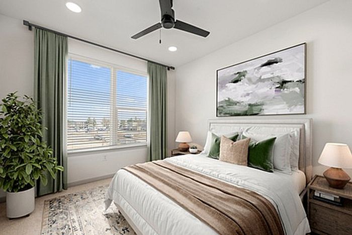 Bright and cozy bedroom with modern decor, featuring large window views, elegant furnishings, and lush greenery.