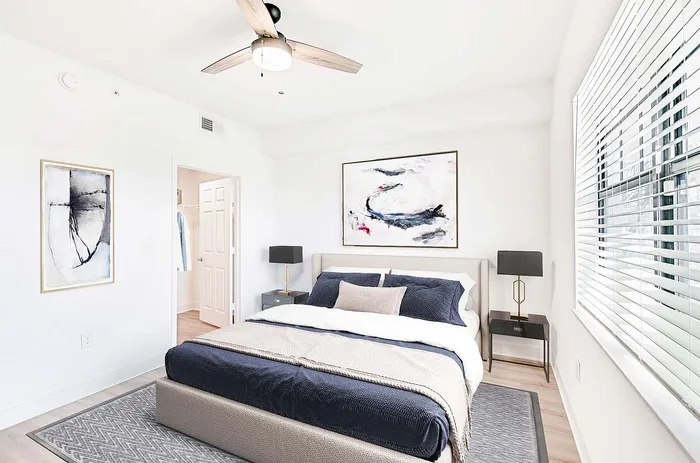 Bright and modern bedroom with stylish decor, cozy bed, and large window inviting natural light.