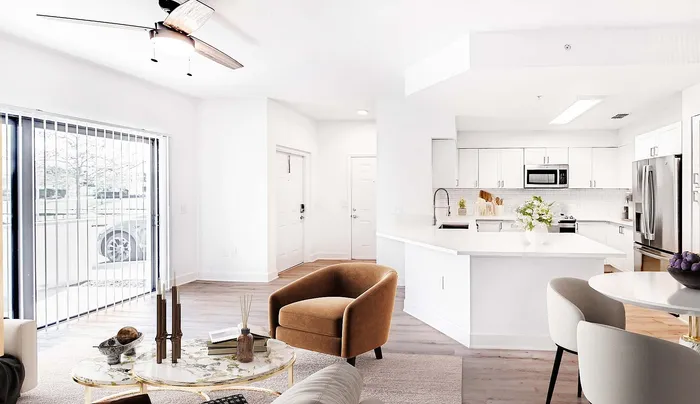 Bright and modern open-concept living area featuring a stylish kitchen with stainless steel appliances, cozy seating, and natural light from large sliding glass doors.