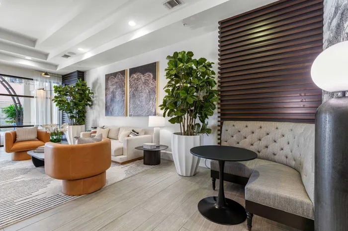 Elegant living space featuring modern decor, plush seating, large indoor plants, and artistic wall panels, perfect for relaxation and entertaining.