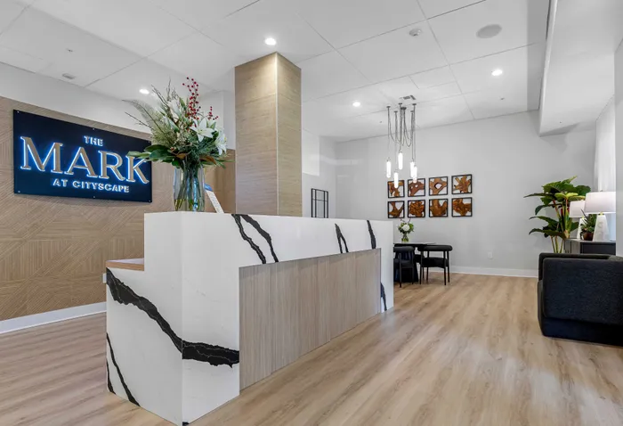 Elegant apartment lobby with a stylish marble reception desk, contemporary lighting, and modern artwork at The Mark at Cityscape.