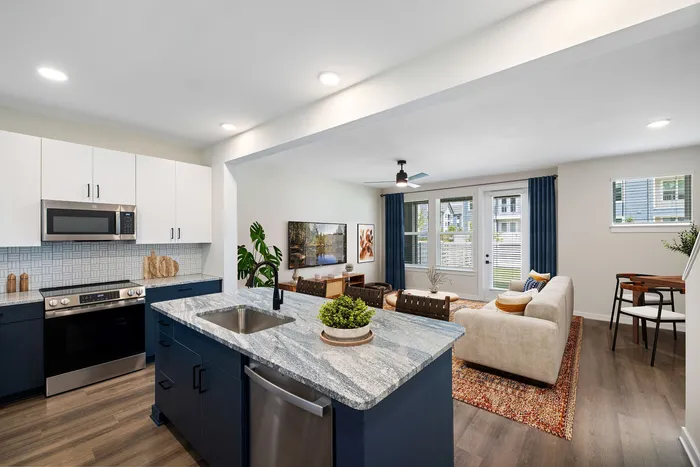 Modern open-concept kitchen and living room with sleek cabinetry, stylish decor, and abundant natural light.