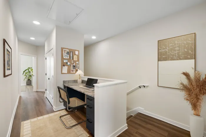 Chic hallway workspace with desk, stylish chair, and inviting natural light, perfect for a modern home office.