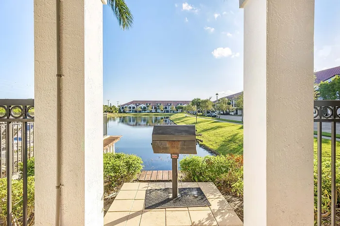 Charming balcony view featuring a tranquil pond with lush greenery, perfect for relaxation or entertaining with a built-in BBQ.