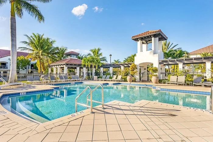 Vibrant poolside oasis surrounded by lush palm trees and stylish cabanas, perfect for relaxation.