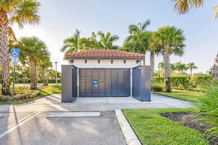 Charming outdoor mail facility with elegant design, set against a backdrop of lush palm trees and manicured greenery.
