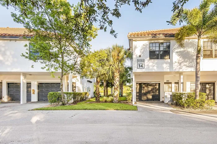Charming townhouse with lush landscaping, featuring elegant architecture and a serene atmosphere in a peaceful neighborhood.