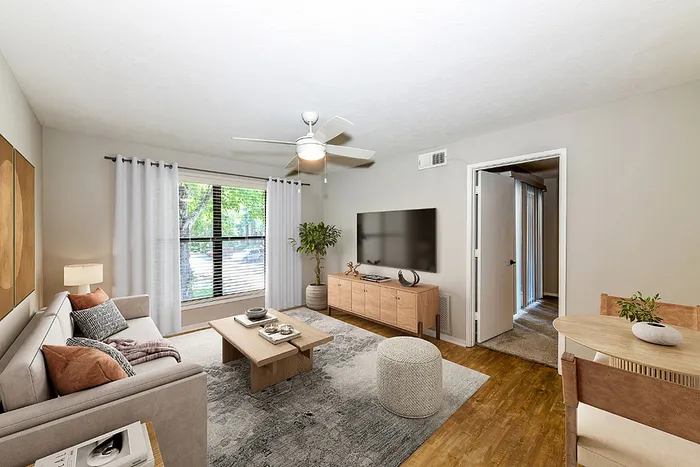 Bright and inviting living room with modern decor, cozy sofa, and ample natural light through large windows.