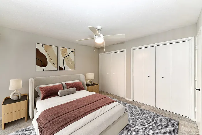 Elegant bedroom with modern decor, featuring a cozy double bed, abstract wall art, and ample closet space.