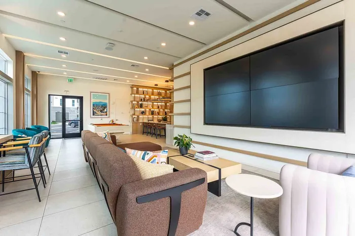 Clubroom area with plush seating, sleek wall-mounted TV, and stylish decor, perfect for entertaining.