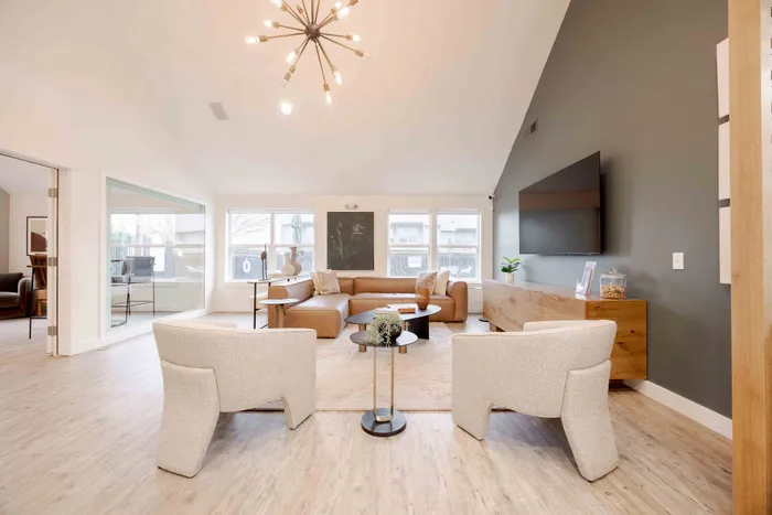 Modern living room with sleek furniture, large windows, and stylish lighting, creating an inviting and cozy atmosphere.