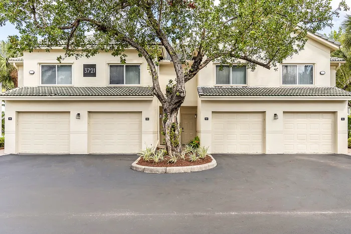 Charming duplex with lush greenery, featuring modern garages and inviting residential appeal.