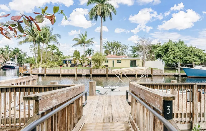 Charming waterfront view showcasing a serene dockside setting with palm trees and clear blue skies. Ideal for nature lovers seeking tranquility.