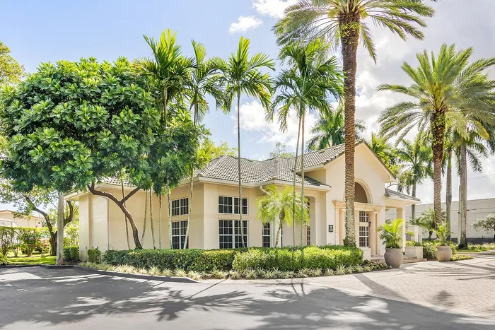 Charming residential building surrounded by lush palm trees, offering a serene tropical ambiance and elegant architectural design.