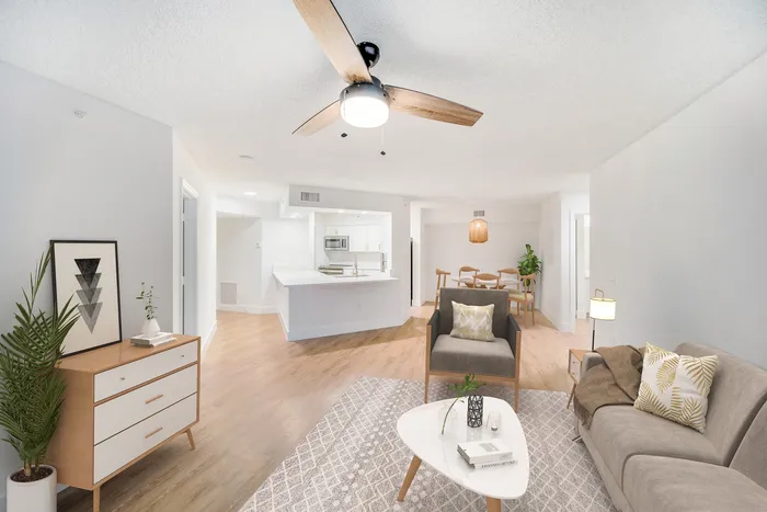 Inviting open-concept living space with modern kitchen, cozy seating area, and elegant dining setup. Features stylish decor and warm wooden flooring.