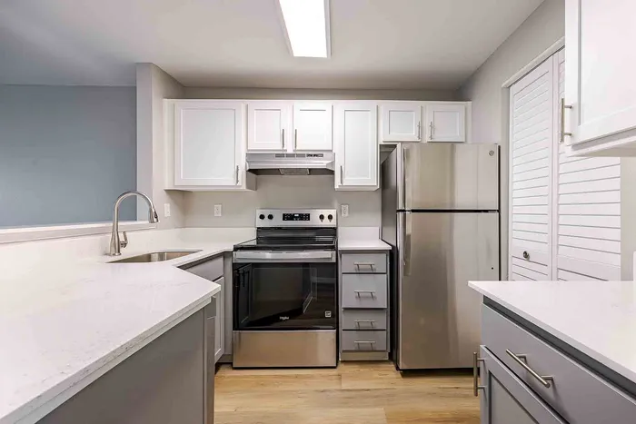 Modern kitchen with sleek stainless steel appliances, white cabinetry, and elegant countertops.