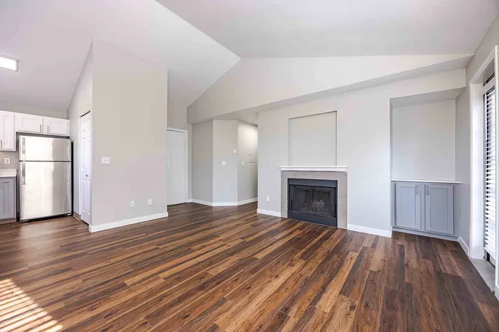 Bright and airy living space with sleek hardwood floors, a modern fireplace, and a contemporary kitchen featuring stainless steel appliances.