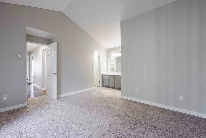 Inviting bedroom with plush carpet and modern en-suite bathroom, offering a serene and comfortable living space.