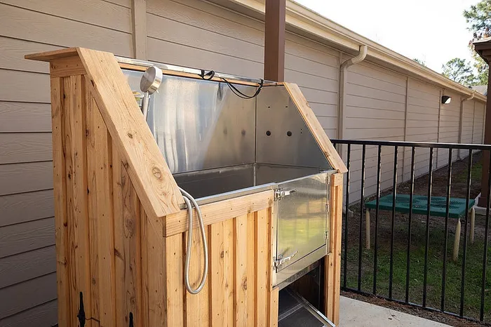 Charming outdoor wooden dog wash station with modern amenities, perfect for pet-friendly homes.