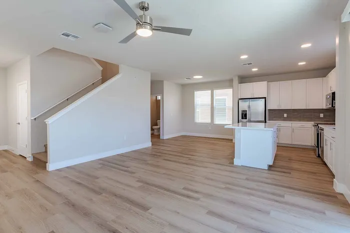 Modern open-concept living space with sleek kitchen, spacious layout, and elegant wood flooring.