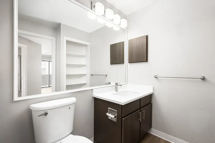 Contemporary bathroom featuring a sleek vanity with ample mirror space, elegant fixtures, and modern lighting.