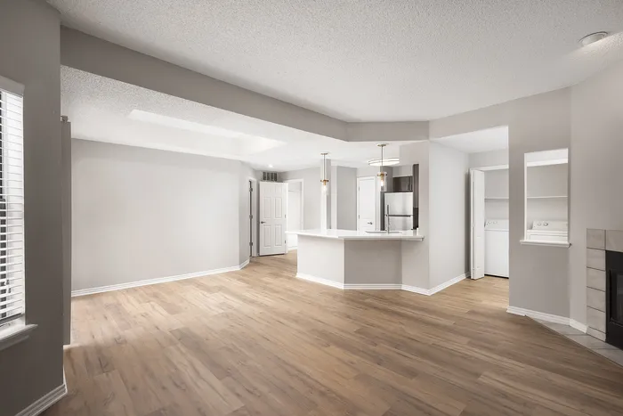 Spacious open-plan apartment with elegant hardwood floors, modern kitchen island, and ample natural light.