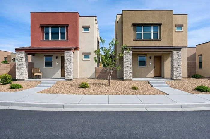 Modern duplex homes with unique earthy tones and contemporary stone accents, set in a beautifully landscaped neighborhood.