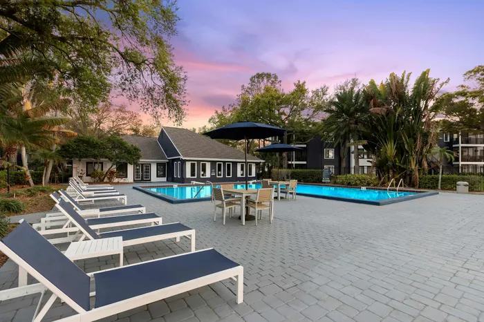 Inviting outdoor area with a sparkling swimming pool, cozy seating, and lush greenery, perfect for relaxation and leisure.