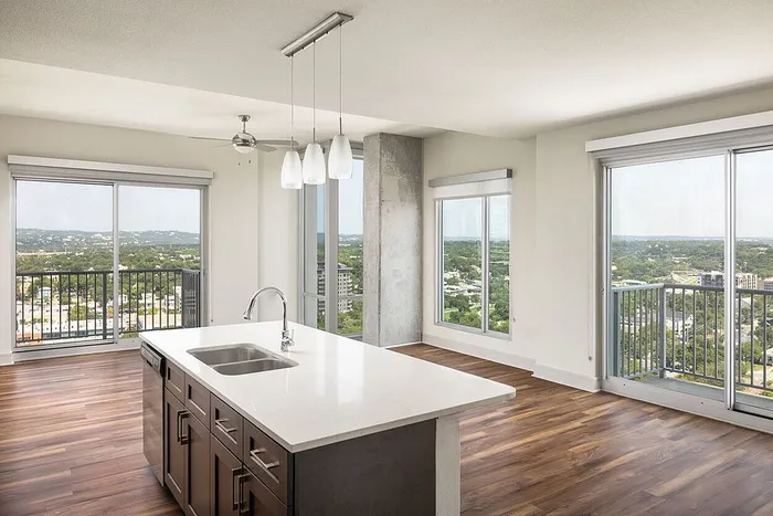 Modern apartment kitchen with sleek island and breathtaking panoramic views from large windows.