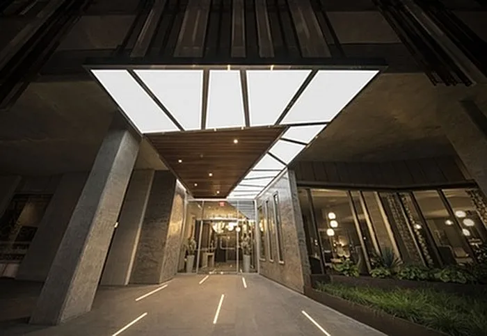 Modern apartment entryway with sleek architectural design, featuring sophisticated lighting and lush greenery.