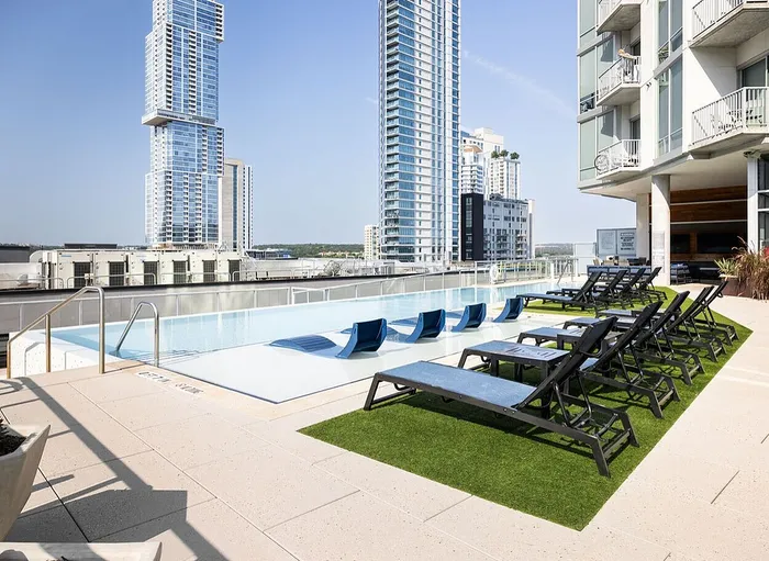 Luxurious rooftop infinity pool with sun loungers and stunning cityscape views.
