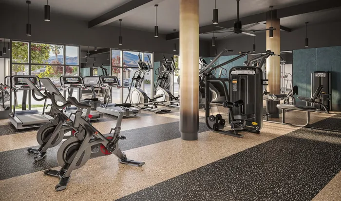 Modern fitness center with state-of-the-art equipment, including treadmills, stationary bikes, and weight machines, offering a vibrant and well-lit workout environment.