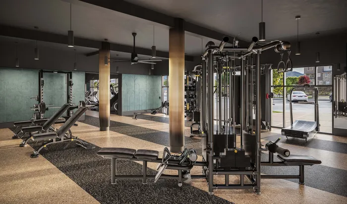 Modern fitness center with state-of-the-art gym equipment, sleek design, and large windows offering a bright, inviting atmosphere.