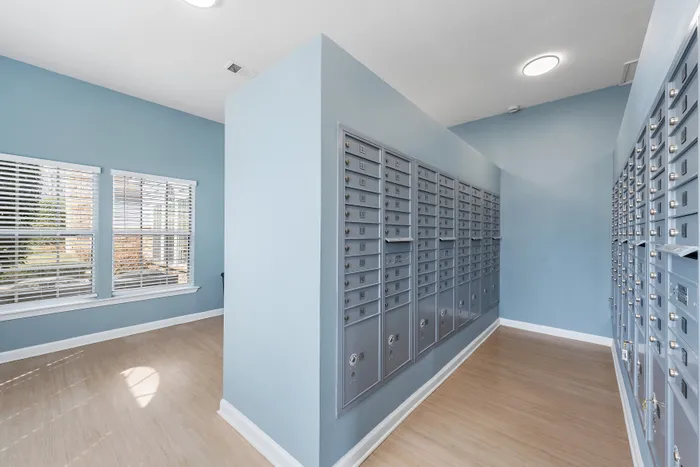 Modern mailroom with sleek blue walls and ample natural light for a welcoming atmosphere.