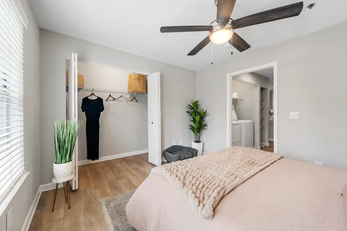 Chic bedroom featuring elegant hardwood floors, ample closet space, and cozy bedding with modern decor.