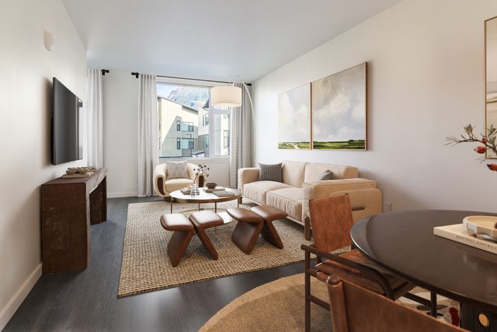 Chic living room with modern decor, featuring a cozy beige sofa, stylish wooden coffee table, and large window with scenic views.