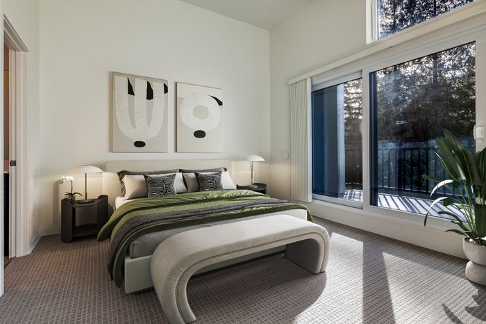 Elegant bedroom with modern art, plush bedding, and private balcony access offering serene views.