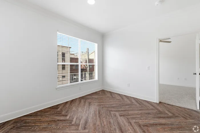 Bright, airy room with elegant hardwood floors and large window.