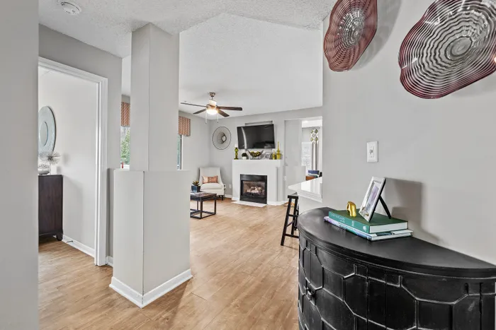 Elegant living area with modern decor, hardwood floors, and a cozy fireplace, perfect for relaxing and entertaining.