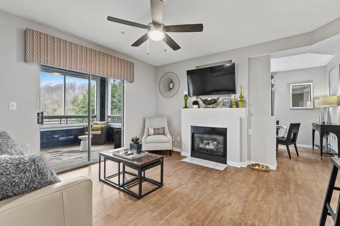 Inviting living room with a cozy fireplace, elegant decor, and access to a scenic balcony through sliding glass doors.