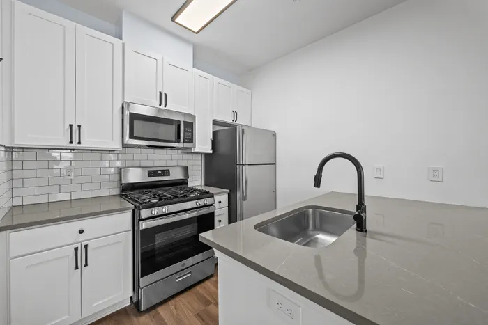 Modern kitchen with sleek stainless steel appliances, elegant white cabinetry, and a chic subway tile backsplash.