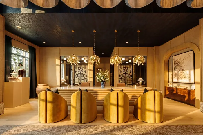 Luxurious living room with elegant golden lighting, plush yellow chairs, and sophisticated decor, creating a warm and inviting atmosphere.