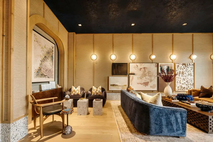 Luxurious living room with elegant decor, featuring a plush blue sofa, modern artwork, and warm ambient lighting, perfect for relaxation and entertaining.