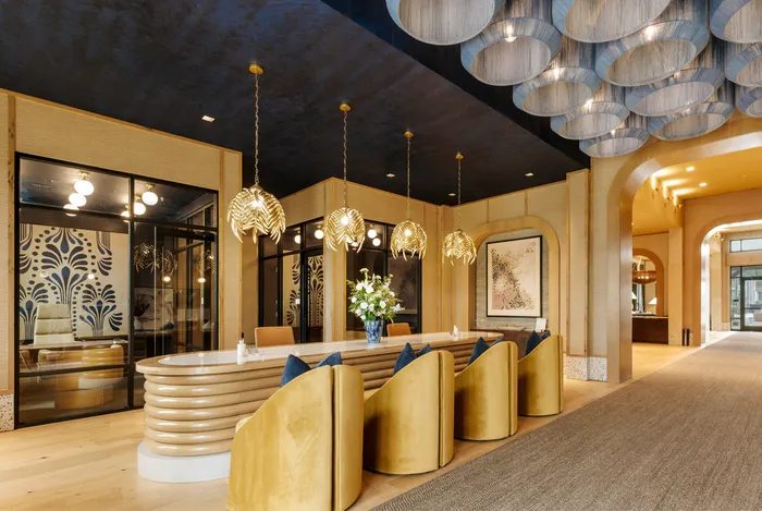 Luxurious lobby with elegant lighting, plush gold seating, and artistic decor, creating a welcoming and refined atmosphere.