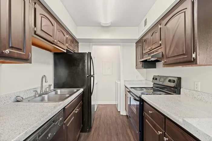 Elegant kitchen with dark wood cabinetry, modern appliances, and sleek countertops, creating a warm and inviting culinary space.