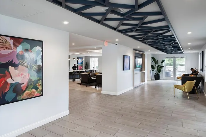 Modern and inviting lobby space with sleek tile flooring, artistic wall decor, and cozy seating areas, perfect for relaxation and socializing.